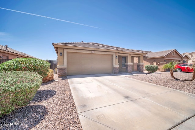 16887 W Belleview St, Goodyear, AZ 85338 - view of front of house featuring stone siding, stucco siding, an attached garage, and concrete driveway