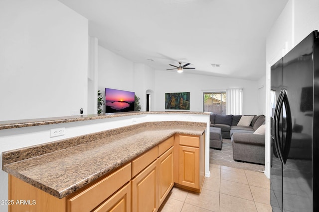 16887 W Belleview St, Goodyear, AZ 85338 - kitchen with black fridge with ice dispenser, vaulted ceiling, open floor plan, light tile patterned flooring, and ceiling fan