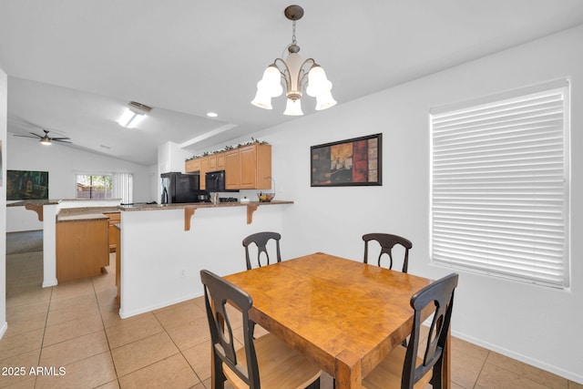 16887 W Belleview St, Goodyear, AZ 85338 - dining area with light tile patterned floors, vaulted ceiling, a ceiling fan, a chandelier, and baseboards