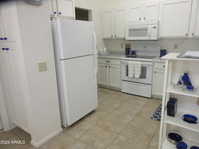 kitchen featuring white cabinetry, light tile patterned floors, and white appliances