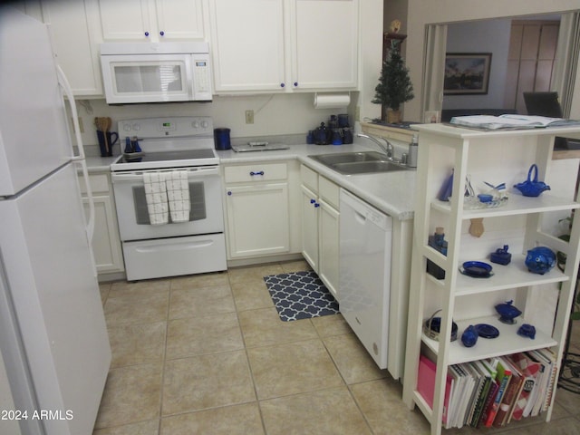 kitchen featuring kitchen peninsula, white appliances, sink, light tile patterned floors, and white cabinetry