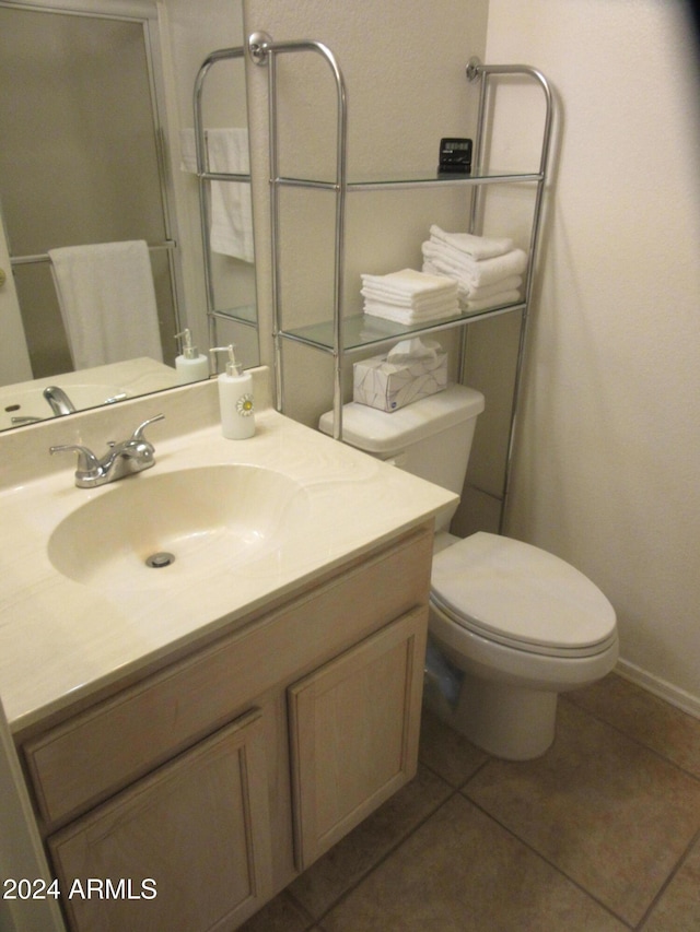 bathroom with tile patterned floors, vanity, toilet, and walk in shower