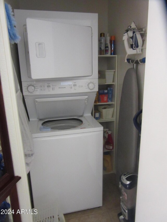 washroom featuring tile patterned flooring and stacked washer and dryer