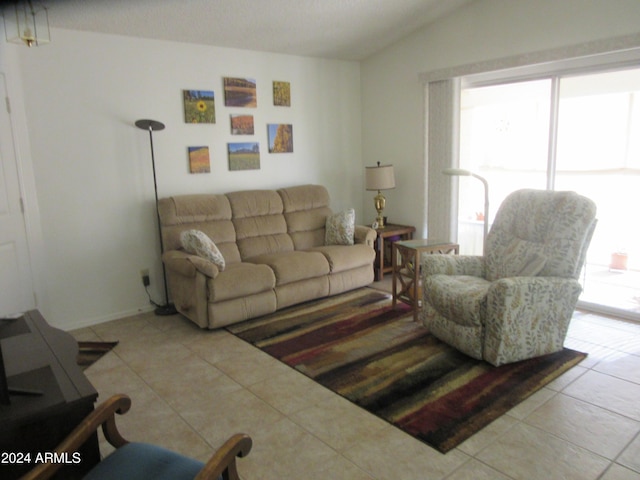 living room with light tile patterned flooring and vaulted ceiling