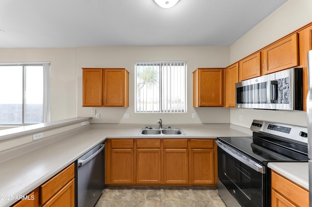 4234 S 62nd Ln, Phoenix, AZ 85043 - kitchen with brown cabinetry, appliances with stainless steel finishes, light countertops, and a sink