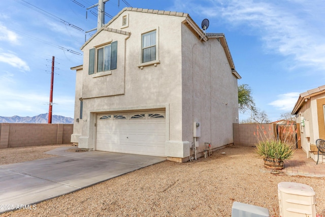 4234 S 62nd Ln, Phoenix, AZ 85043 - view of side of home featuring concrete driveway, an attached garage, fence, and stucco siding