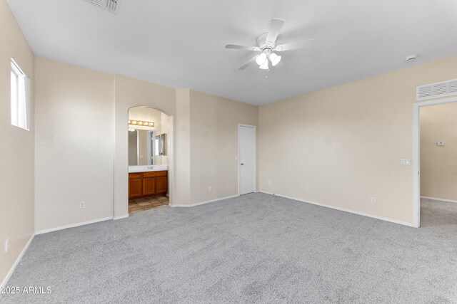 4234 S 62nd Ln, Phoenix, AZ 85043 - unfurnished bedroom with ensuite bath, baseboards, arched walkways, and carpet floors