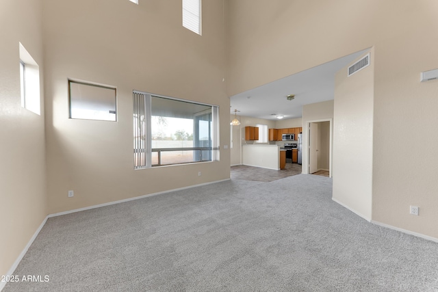 4234 S 62nd Ln, Phoenix, AZ 85043 - unfurnished living room with visible vents, light carpet, a high ceiling, and baseboards