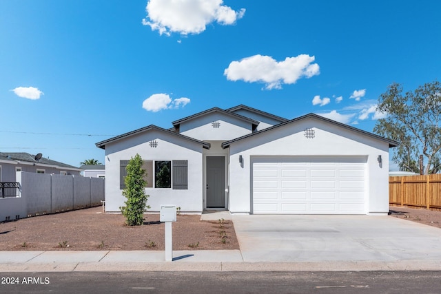 ranch-style home featuring stucco siding, driveway, an attached garage, and fence