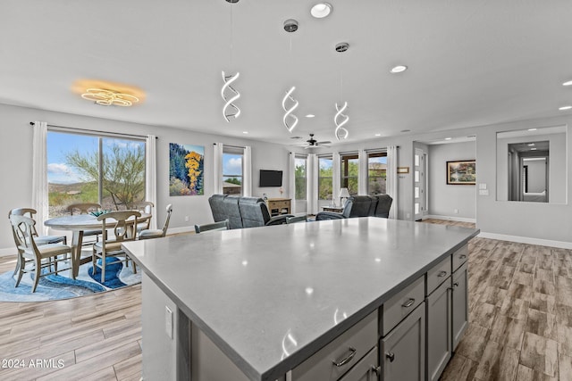 kitchen with light wood-type flooring, pendant lighting, and plenty of natural light