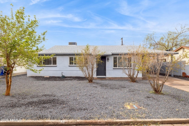 ranch-style house featuring stucco siding and a shingled roof