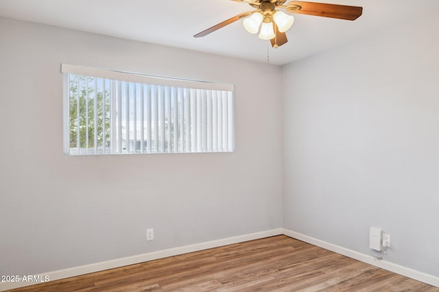 empty room with ceiling fan, baseboards, and wood finished floors