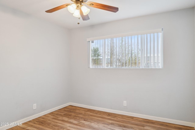 empty room featuring a ceiling fan, baseboards, and wood finished floors