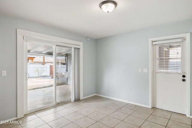 unfurnished room with light tile patterned floors and baseboards