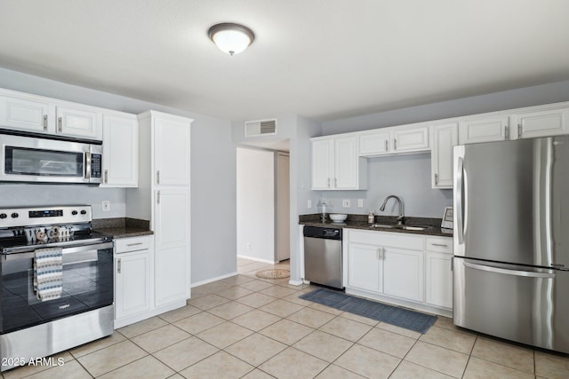 kitchen with visible vents, light tile patterned floors, white cabinets, stainless steel appliances, and a sink