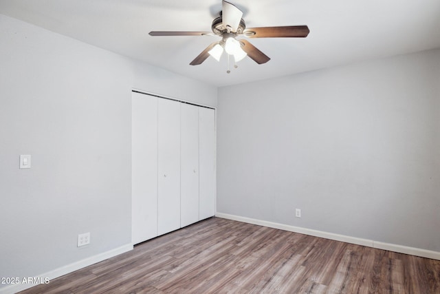 unfurnished bedroom with ceiling fan, a closet, baseboards, and wood finished floors