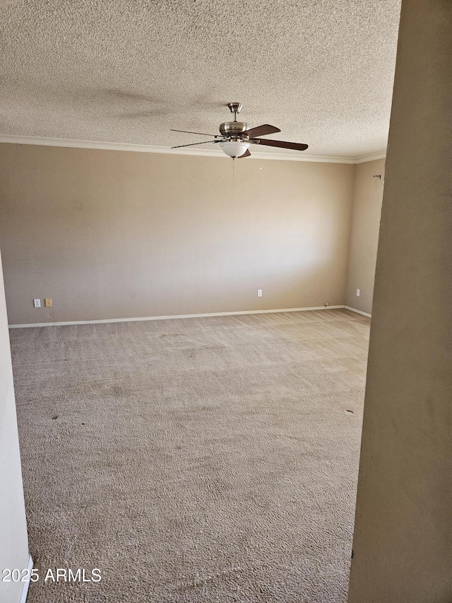 carpeted empty room with ceiling fan, a textured ceiling, and ornamental molding