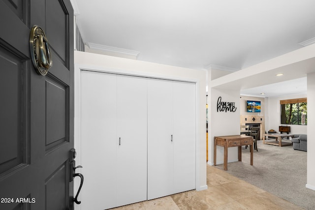 tiled foyer entrance featuring crown molding