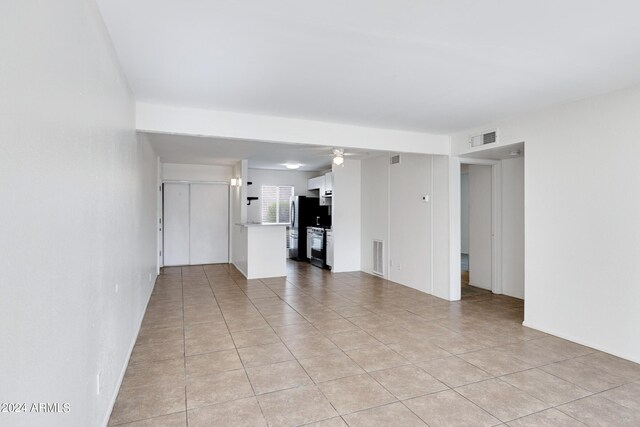 empty room featuring ceiling fan and light tile patterned floors