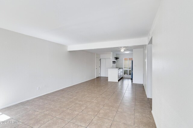 unfurnished living room with ceiling fan and light tile patterned floors