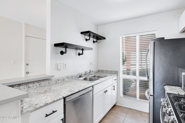 kitchen with white cabinets, light tile patterned flooring, sink, and appliances with stainless steel finishes