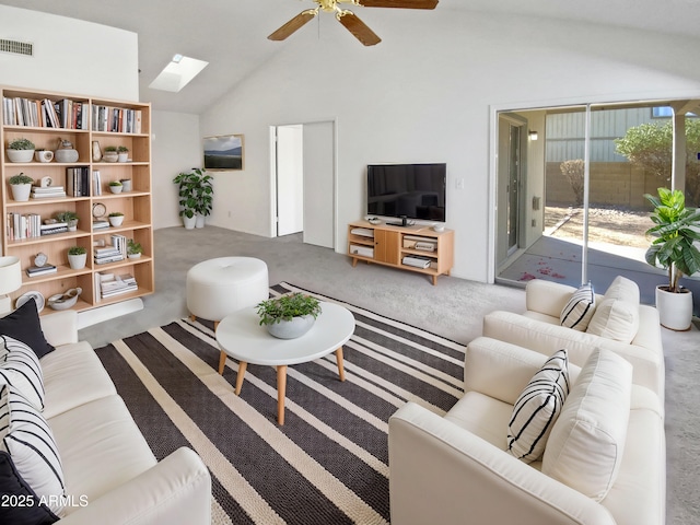 carpeted living room featuring ceiling fan and vaulted ceiling with skylight