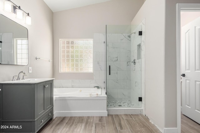 bathroom featuring independent shower and bath, wood-type flooring, plenty of natural light, and vanity