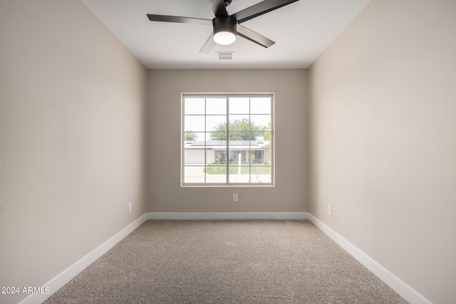 unfurnished room with ceiling fan and carpet