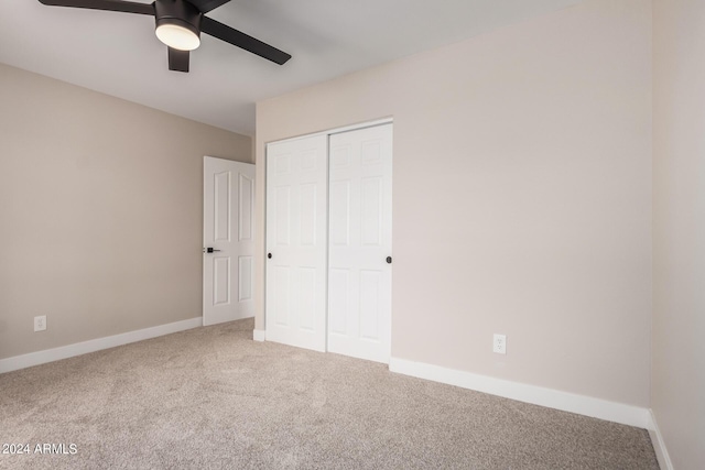 unfurnished bedroom with ceiling fan, carpet flooring, and a closet