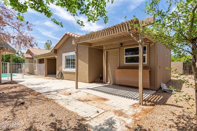 rear view of house featuring a pergola and a patio