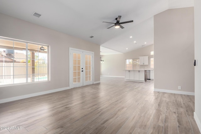 unfurnished living room featuring french doors, ceiling fan, vaulted ceiling, and light wood-type flooring