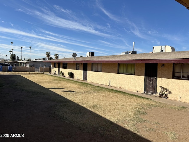 exterior space featuring central AC unit and fence