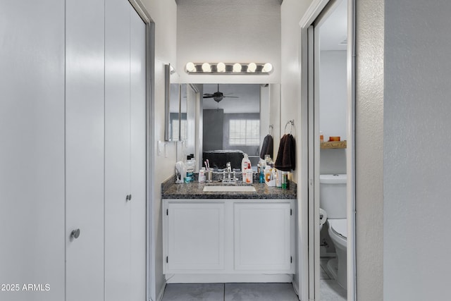 bathroom featuring vanity, ceiling fan, and toilet