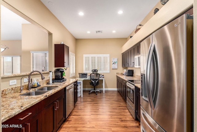 18650 N 91st Ave Unit 3301, Peoria, AZ 85382 - kitchen featuring appliances with stainless steel finishes, a sink, light wood finished floors, light stone countertops, and recessed lighting
