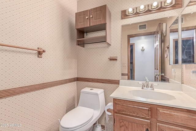 bathroom featuring wallpapered walls, toilet, and vanity