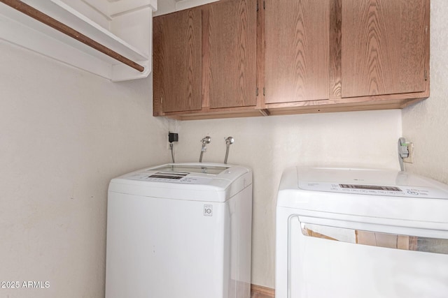 washroom featuring separate washer and dryer and cabinet space