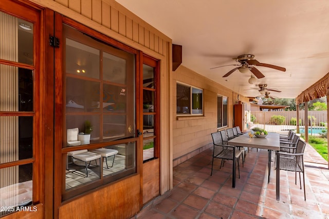 view of patio / terrace featuring outdoor dining space, fence, and a ceiling fan