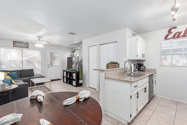 kitchen featuring visible vents, a sink, ceiling fan, white cabinets, and stainless steel dishwasher