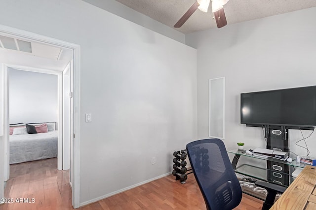 office with baseboards, a textured ceiling, light wood-style floors, and a ceiling fan