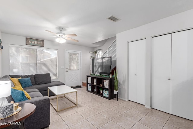 living room with light tile patterned floors, visible vents, and ceiling fan