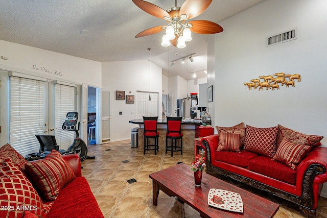 living room with visible vents, a textured ceiling, ceiling fan, and high vaulted ceiling