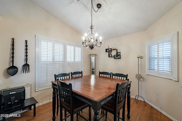 dining room featuring vaulted ceiling, wood finished floors, and a wealth of natural light