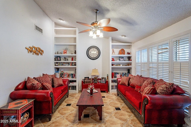 living area with visible vents, built in shelves, a textured ceiling, and lofted ceiling