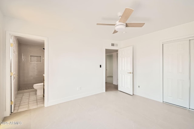 unfurnished bedroom with a closet, ensuite bath, baseboards, ceiling fan, and light tile patterned floors