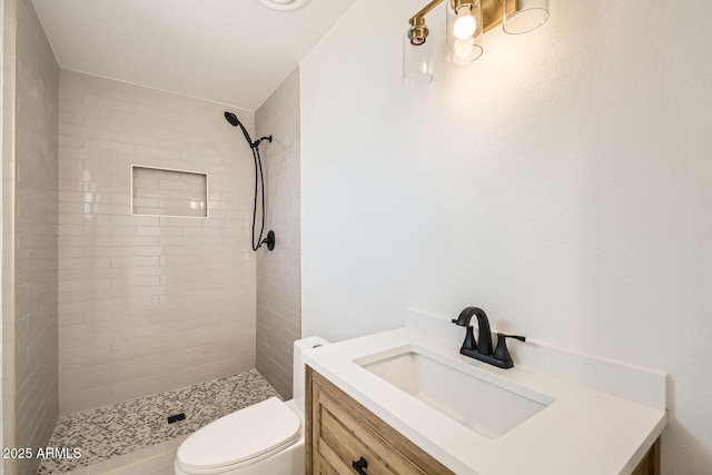 bathroom featuring a stall shower, toilet, and vanity