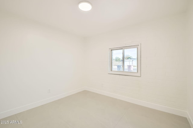 empty room with baseboards and light tile patterned floors