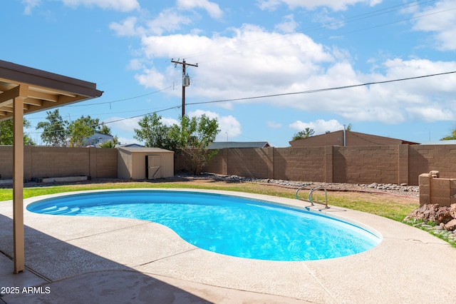 view of swimming pool with a fenced backyard, a storage unit, an outbuilding, and a patio area