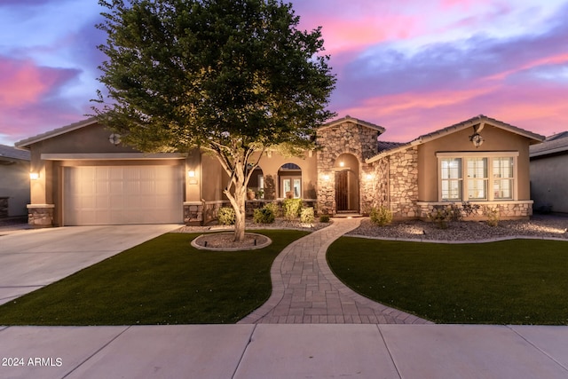 mediterranean / spanish home with a garage and a lawn