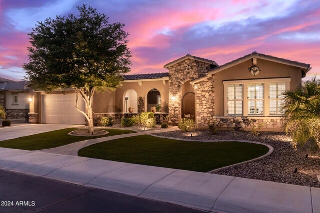 mediterranean / spanish-style home featuring a lawn and a garage