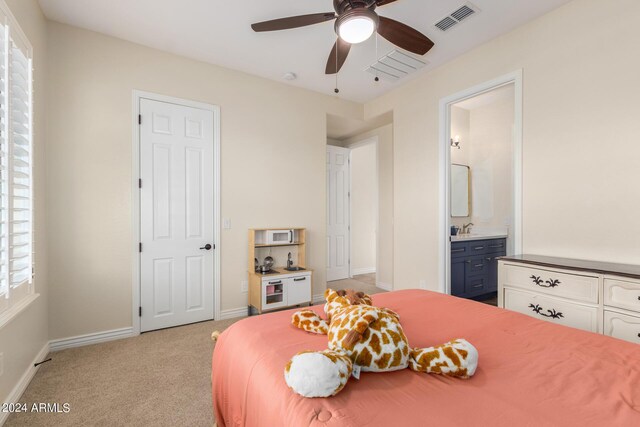 carpeted bedroom with ceiling fan and ensuite bathroom